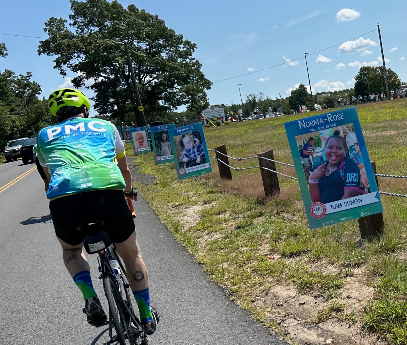 A person riding a bike on a road with posters on the side
AI-generated content may be incorrect.