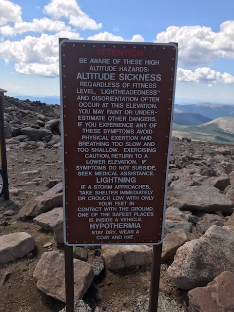 A sign on the side of a mountain
Description automatically generated